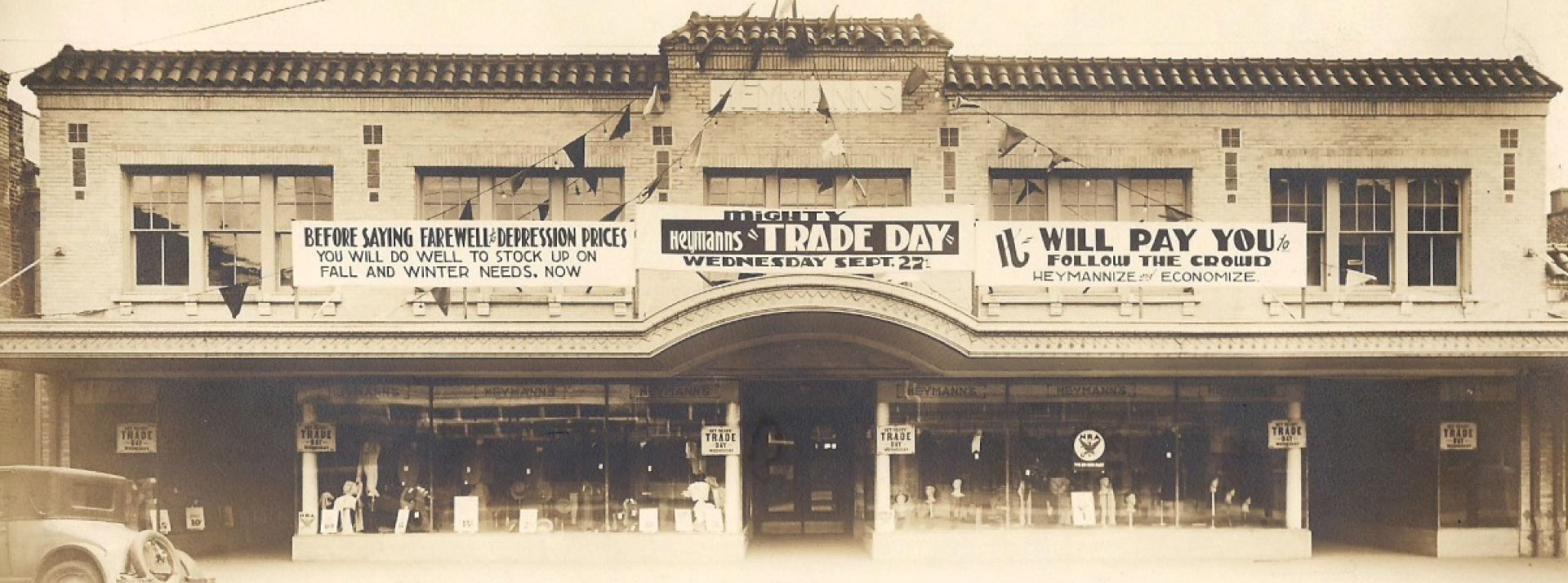 Heymann’s storefront in Lafayette, with display windows and Trade Day banners, 1916